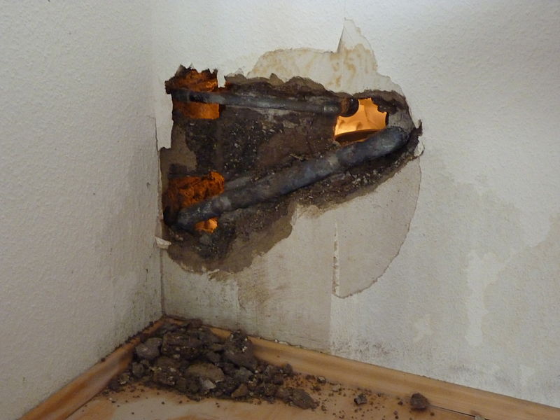 Opened wall exposing a pipe